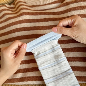 Detail showing the elastic ribbed cuff and soft knit texture of these striped socks