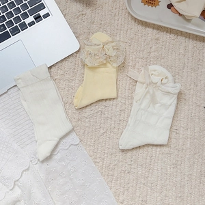 Detailed view of sweet ballet style socks with lace bows and cream yellow ribbon accents