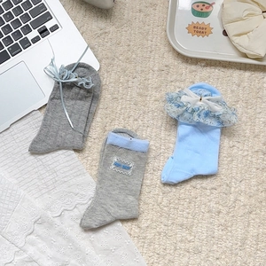 Détail de chaussettes à carreaux bleu gris avec rubans et dentelle florale