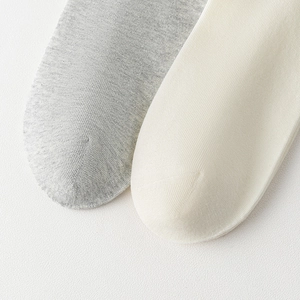 Close-up of seamless toe stitching and soft knit texture of off-white cotton socks