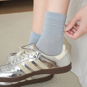 Breathable light blue crew socks in cream color style paired with silver retro sneakers