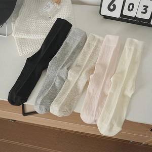 Dettaglio della trama in maglia di cotone e dei motivi a righe verticali su calze al ginocchio