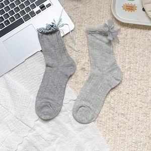 Détail de chaussettes à carreaux gris avec dentelle et jolis nœuds en ruban bleu