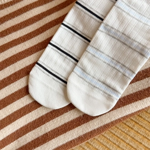 Detail of white cotton blend striped socks with fine ribbed texture and elastic band