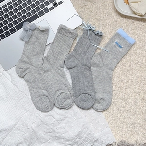 Lot de quatre chaussettes en tricot gris-bleu avec nuds en ruban et détails en dentelle