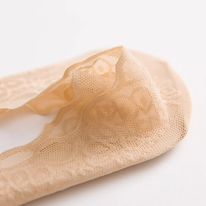 Macro view of beige lace low cut socks with delicate floral mesh and scalloped edges