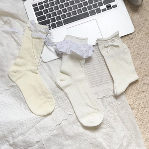 Detailed view of Lolita style white lace socks with bows and frill textures