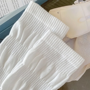 Detailed macro view of white cable knit texture and ribbed cuffs on jk calf socks