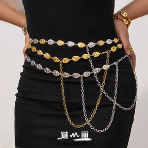 Detail of multi-layered water drop metal belt with gold and silver tassels on model