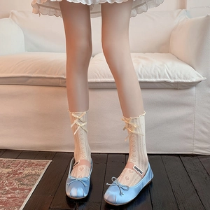 Detail of sweet hollow heart pattern socks with blue ballet flats and ribbon bow accents