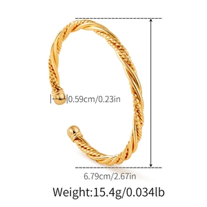 Détail macro du bracelet jonc doré torsadé avec des extrémités sphériques rondes
