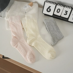 Trama in maglia dettagliata di calze rosa, beige e grigie in morbido tessuto di cotone