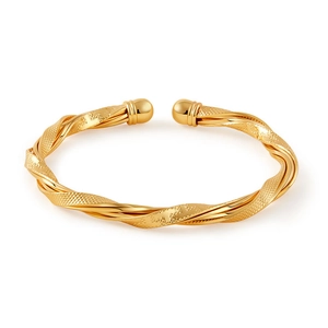 Détail du bracelet jonc torsadé doré montrant la texture grainée et les boules