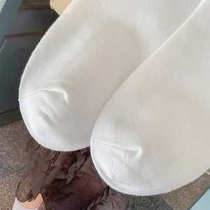 Detail of flat seam craftsmanship on white cotton knee-high socks for a smooth toe fit