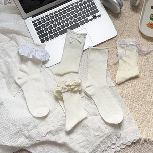 Detail of five cream white Lolita style lace socks with ribbons and floral hollow patterns