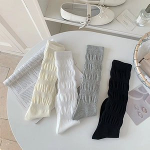 Detail view of cotton blend knee high socks featuring vertical pleated texture in four colors