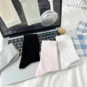 Gros plan de chaussettes en coton respirant pastel sur un clavier d'ordinateur