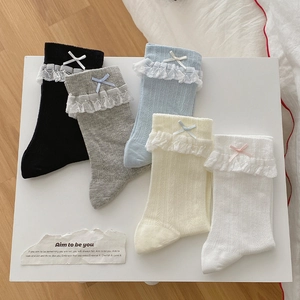 Dettaglio di cinque paia di calze di cotone con pizzo delicato e piccoli fiocchi decorativi