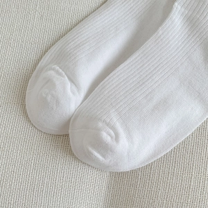 Detailaufnahme weißer gerippter Socken mit nahtloser Spitze und feiner Texturierung