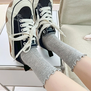Light gray mid-calf socks with vertical rib knit and sweet lettuce edge cuff detail