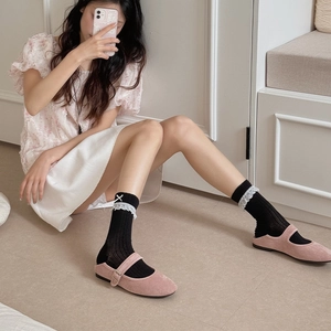 Scarpe Mary Jane rosa in camoscio con calze nere in pizzo e dettaglio fiocco
