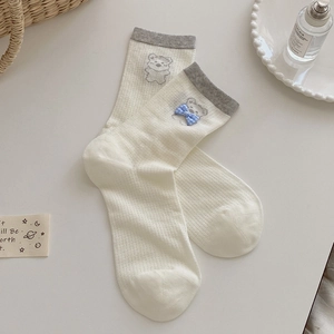 Détail de chaussettes mi-mollet blanc crème avec broderie ours et bord-côte gris