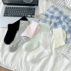 Gros plan détaillé de chaussettes en coton respirant aux couleurs pastel sur un lit doux
