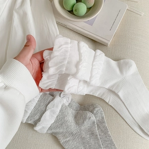 Nahaufnahme von Ballett-Rippsocken mit zweilagigen Rüschen-Spitzenbündchen in Cremeweiß