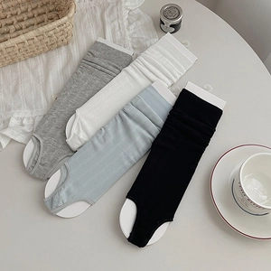 Flat lay of ribbed knit stirrup leg warmers in grey, white, blue, and black colors
