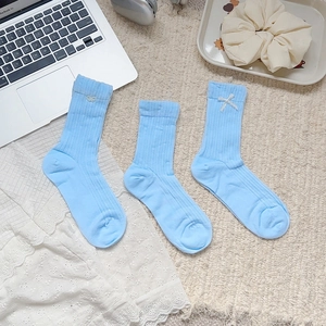 Chaussettes mi-mollet bleu clair avec broderie nœud blanc et texture côtelée