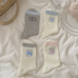 Détail de broderie d'ours mignon avec nœuds 3D sur des chaussettes en résille