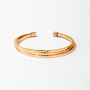 Détail d'un bracelet jonc ouvert à trois couches plaqué or avec effet martelé
