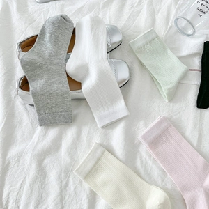 Détail de chaussettes mi-mollet en maille côtelée aux couleurs pastel de style ballet