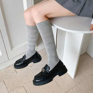 Classic grey calf socks with vertical stripe texture worn with black platform shoes