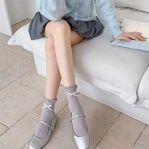 Detail showing ruffle cuffs and white ribbon bows on soft cotton mid-calf crew socks