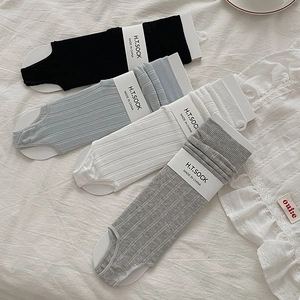 Detailed view of vertically ribbed cotton flip-flop socks in black, blue, white, and grey