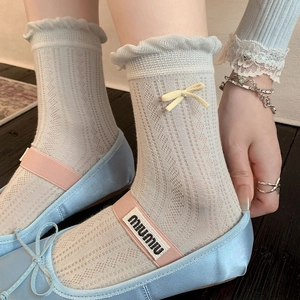 Detail of light blue mesh socks with delicate frill edges and yellow bow accents