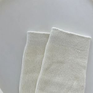 Close-up of fine ribbed texture on white knitted ballet-style leg warmers