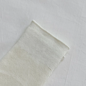 Gros plan sur les jambières en maille blanche avec texture côtelée fine et douce