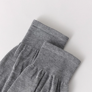 Detailed macro view of the grey elastic cuff on breathable mesh stirrup leg warmers