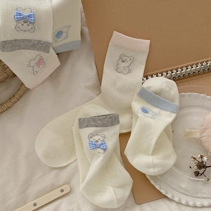 Détail de chaussettes bébé en maille filet respirante avec broderie ours et nœuds 3D