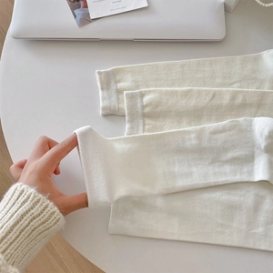 Detailed view of white ribbed knit fabric on calf socks showing elasticity and texture