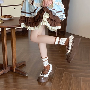 Close-up of vintage brown Mary Janes with lace trim and matching bow pattern socks