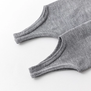 Detailed close-up of grey ribbed knit stirrup leg warmers showing fine stitching and texture