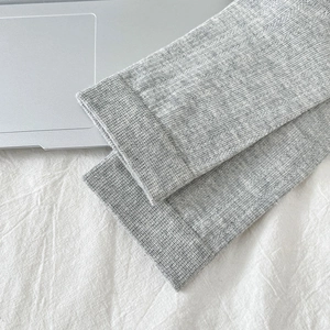 Détail de la texture en maille côtelée gris clair et bords élastiques des chaussettes