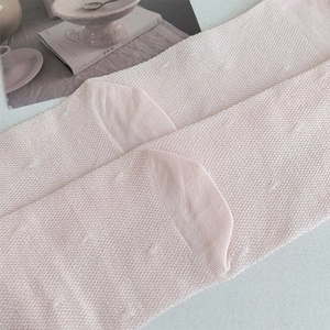 Detail of light pink mesh socks featuring breathable knit texture and ballet core style
