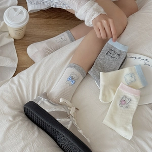 Détail de chaussettes ourson avec nœuds 3D et maille respirante aux couleurs douces