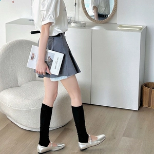 Détail d'une mini-jupe plissée grise avec ceinture assortie et style épuré