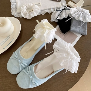 Detail showing white ballet-style ruffle socks with delicate lace and bows