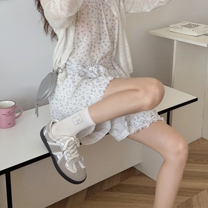 Détail de chaussettes blanches en coton avec broderie ours rose et bordure en dentelle